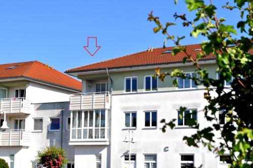 a white building with a red roof at Fewo Wellenreiter Usedom 200 m zum Strand mit Balkon Parkplatz Wlan in Ostseebad Karlshagen