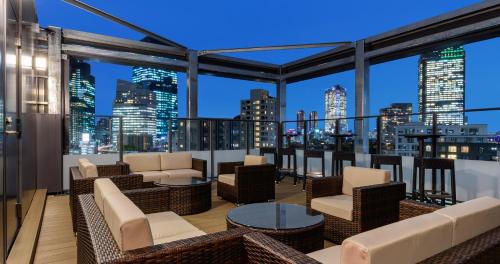 a rooftop patio with chairs and tables and a view of the city at HOTEL SUI AKASAKA by ABEST in Tokyo