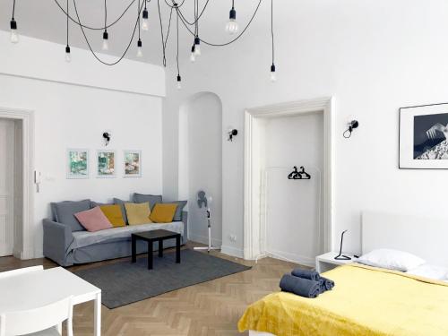 Biały salon z kanapą i łóżkiem w obiekcie Florianska Apartment w Krakowie
