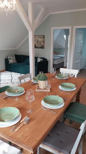 una mesa de madera con platos y copas de vino. en A Zoldbiciklis Haz, en Egerszalók