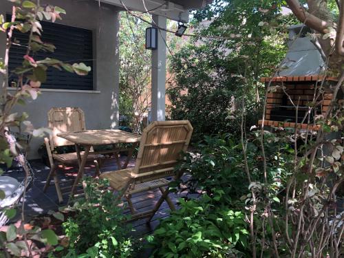 a patio with two chairs and a table in a garden at Studio by the river in Hagoshrim