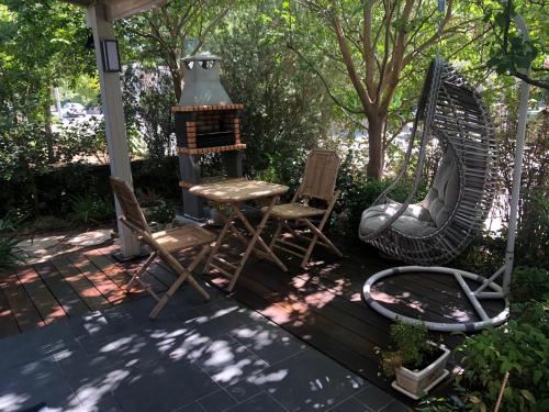 a patio with a swing and a table and chairs at Studio by the river in Hagoshrim