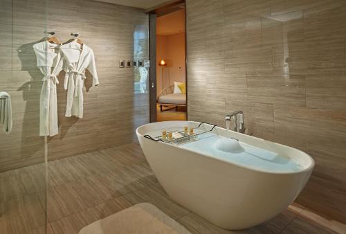 a bathroom with a white bath tub and a shower at Quest Plus Conference Center, Clark in Clark