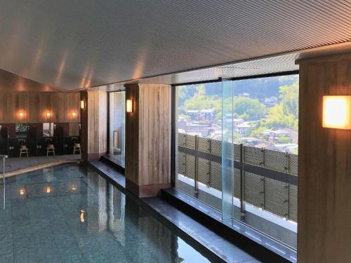 a hotel room with a swimming pool and a large window at Shuzenji Onsen Katsuragawa in Izu