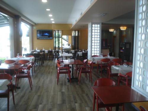 uma sala de jantar com mesas e cadeiras num restaurante em HOSTAL CID em Ourense