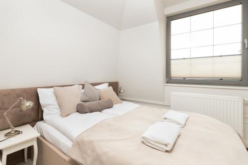 a white bedroom with a bed and a window at Apartments Tartaczna 2 - Gdansk Old Town by Renters in Gdańsk