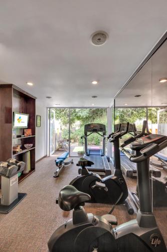 a gym with a bunch of treadmills and ellipticals at Club Mahindra Derby Green, Ooty in Ooty