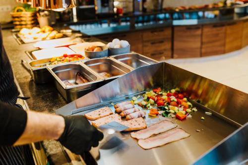 a person preparing food in a restaurant kitchen at Tinschert Hotel-Restaurant-Partyservice in Schwertberg