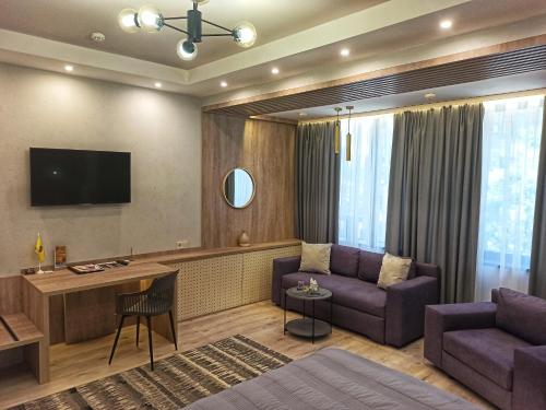 a living room with a couch and a tv at Viva Hotel in Kharkiv