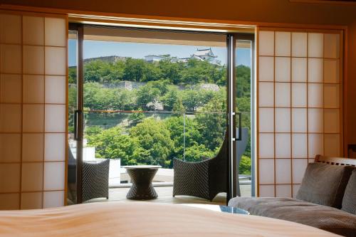 Schlafzimmer mit einem Bett und einem großen Glasfenster in der Unterkunft The Shiroyama Terrace Tsuyama Villa in Tuyama