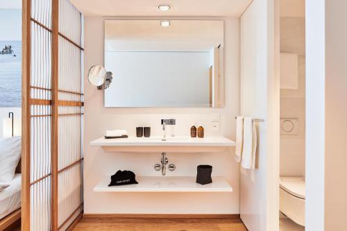 a bathroom with a sink and a mirror at ART HOUSE Basel - Member of Design Hotels in Basel