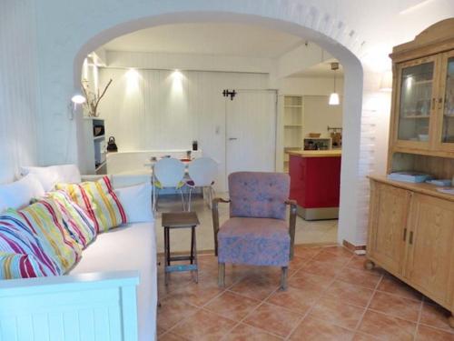 a living room with a white couch and a kitchen at Schwanenhof (EG) in Brodersby