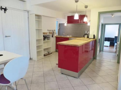 a kitchen with a red island in a room at Schwanenhof (EG) in Brodersby