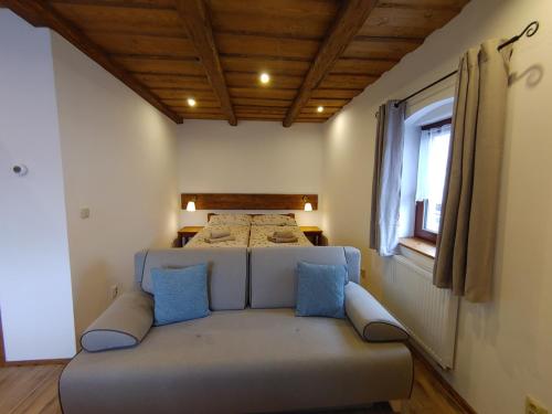 a bedroom with a bed and a couch with blue pillows at U Mikešů in Vyšší Brod