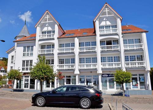 una macchina nera parcheggiata di fronte a un grande edificio di Ferienwohnung am Granitzwald mit B a Ostseebad Sellin