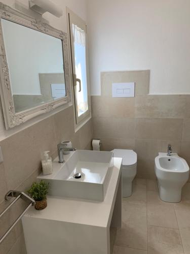 a white bathroom with a sink and a toilet at B&B Somiar in San Teodoro