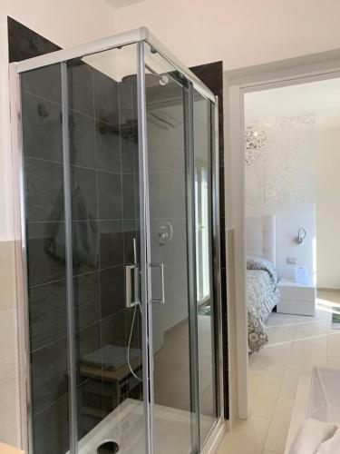 a glass shower in a room with a bedroom at B&B Somiar in San Teodoro