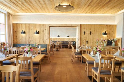 a restaurant with wooden walls and tables and chairs at Hotel Klosterhotel Ludwig der Bayer in Ettal