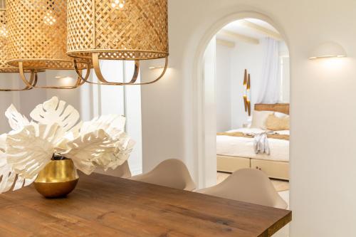 a dining room with a table and a bedroom at Villa Gold & White in Maragkas