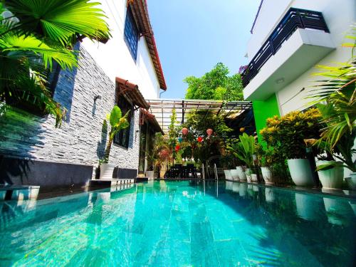a swimming pool in front of a building at Anh Family Homestay in Hoi An