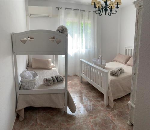 ein Schlafzimmer mit 2 Etagenbetten und einem Kinderbett in der Unterkunft Casa Vista Nevada in Güéjar-Sierra