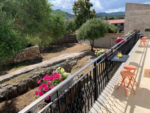 a balcony with pink flowers and a fence at B&B Somiar in San Teodoro