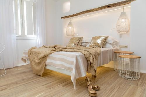 Dormitorio blanco con cama con manta en Villa Gold & White, en Maragkas