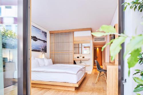 a hotel room with a bed and a desk at ART HOUSE Basel - Member of Design Hotels in Basel