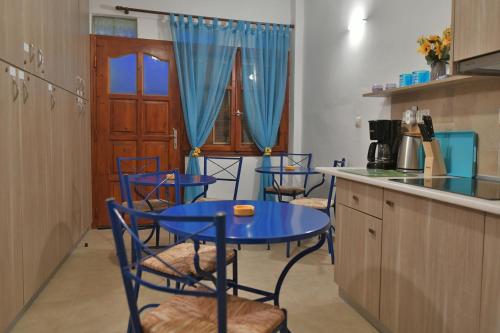 a kitchen with a blue table and chairs in a kitchen at Bella Vita Style rooms & apartments in Pitsidia