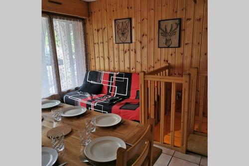 - une salle à manger avec une table et un lit dans l'établissement Charmant appartement 6-8 personnes au cœur du village à proximité lac et pistes de ski, à Morillon