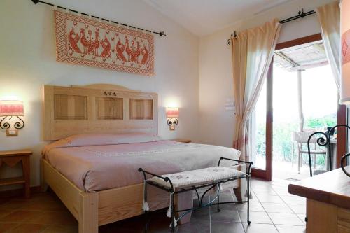 a bedroom with a large bed and a balcony at Hotel Aldiola Country Resort in Sant Antonio Di Gallura
