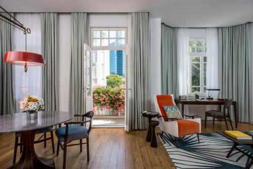 a living room with a table and chairs and a window at The Norman Tel Aviv in Tel Aviv