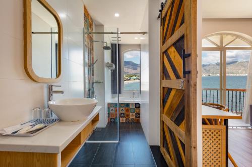 een badkamer met een wastafel en een spiegel bij Hòn Cò Resort - Cà Ná in Thôn Lạc Nghiệp
