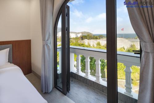 a bedroom with a bed and a large window at SALAH HOTEL in Quy Nhon