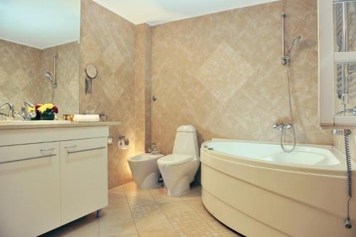 a bathroom with a tub and a toilet and a sink at Hotel Per Astra in Perast