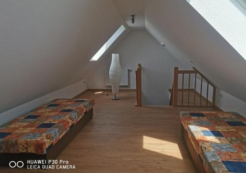 a attic room with two beds and a staircase at Gästewohnung 17 in Oschersleben