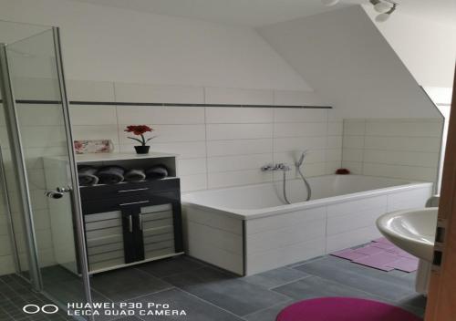 a bathroom with a bath tub and a sink at Gästewohnung 17 in Oschersleben