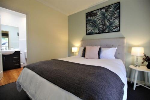 a bedroom with a large bed and a bathroom at Healesville House - Fig Tree House in Healesville