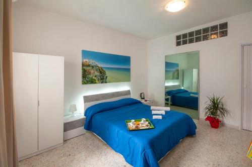 una camera con letto blu e specchio di Anna e Augusto B&B a Lucera