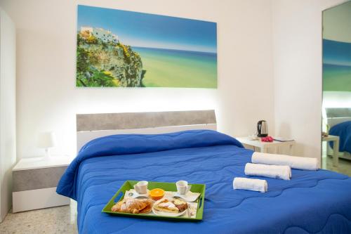 a blue bed with a tray of food on it at Anna e Augusto B&B in Lucera
