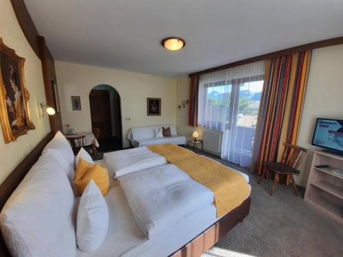 a hotel room with two beds and a television at Gästehaus Burgi in Fügen