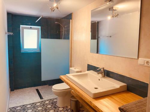 a bathroom with a sink and a toilet and a mirror at Finca Santa Ana in Ojén
