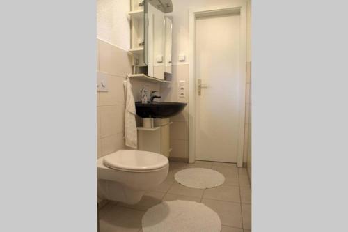 a bathroom with a toilet and a sink at Ferienapartment am See mit Yogaraum und Kajak SUP Verleih in Heidesee