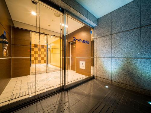 a hallway with a glass door in a building at Super Hotel Nagoya Ekimae in Nagoya
