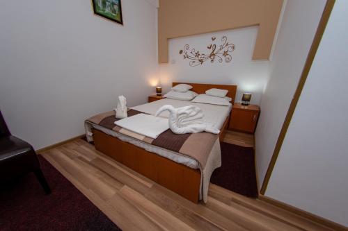 a bedroom with a bed with two swans on it at Karol in Eforie Sud
