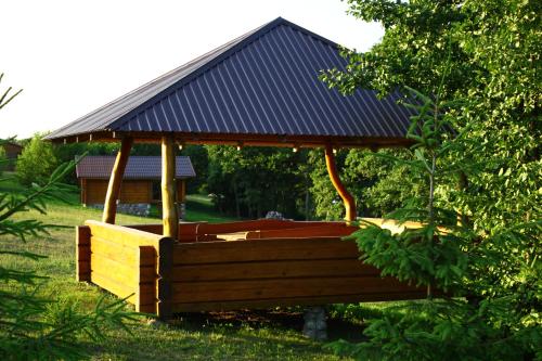 a wooden gazebo with a roof in a yard at Senasis ežeras in Šniūkštai