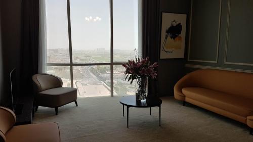 a living room with a vase of flowers on a table at Horizon Manor Hotel in Doha