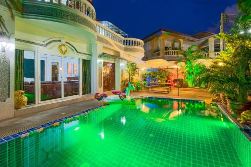 a swimming pool in the backyard of a house at night at RATANA VILLA - PATTAYA HOLIDAY HOUSE WALKING STREET 7 bedrooms in Pattaya South