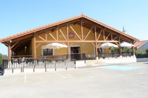 a large building with umbrellas in a parking lot at Posada el Tocinero in Camargo