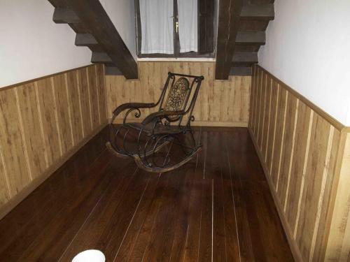 a rocking chair sitting in a room with wooden floors at Posada el Tocinero in Camargo